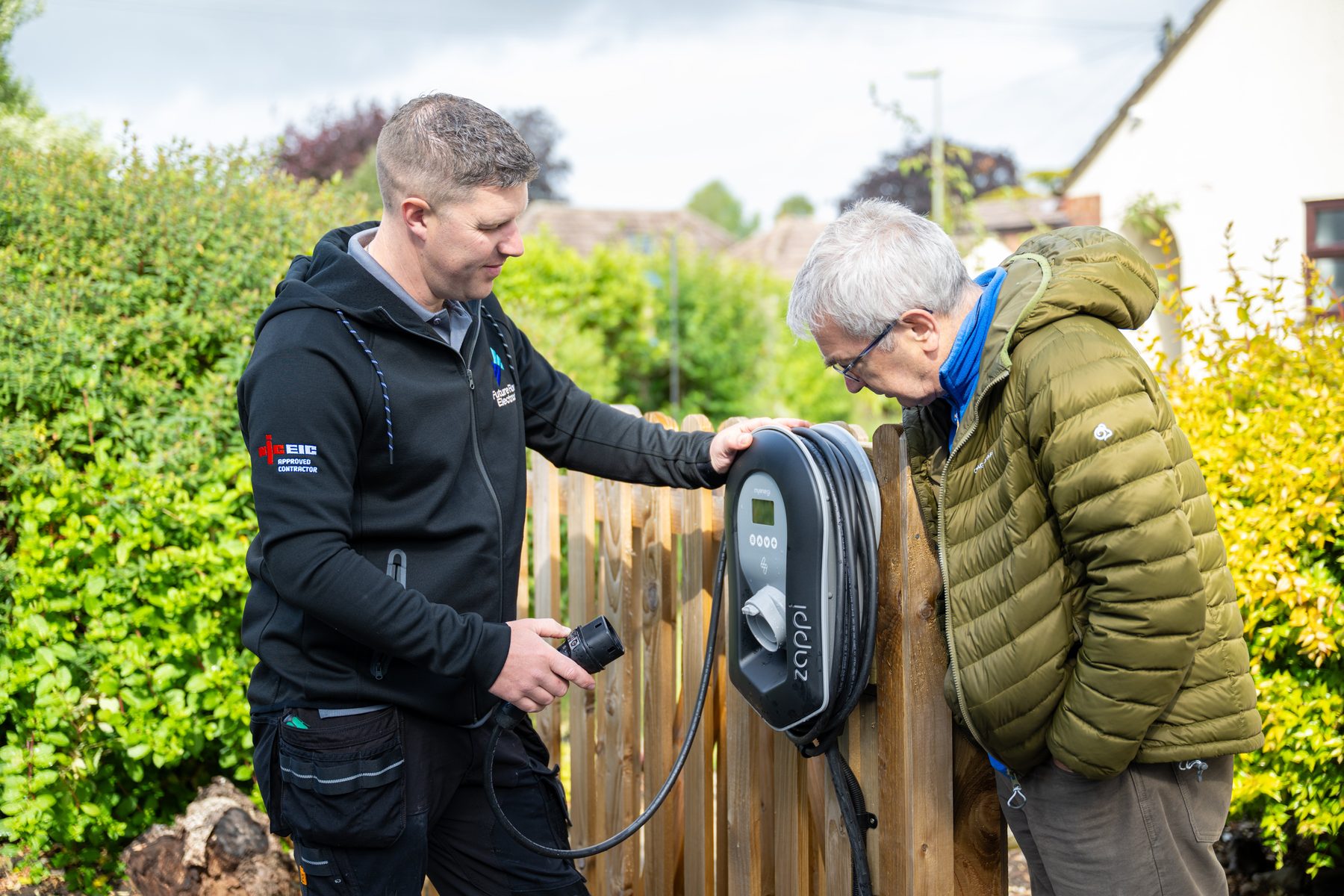 An electrician explaining an EV charger to a customer
