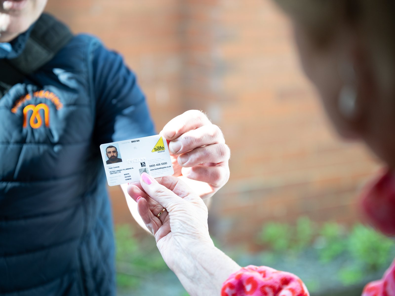 An engineer showing a customer his Gas Safe card, a close detail shot