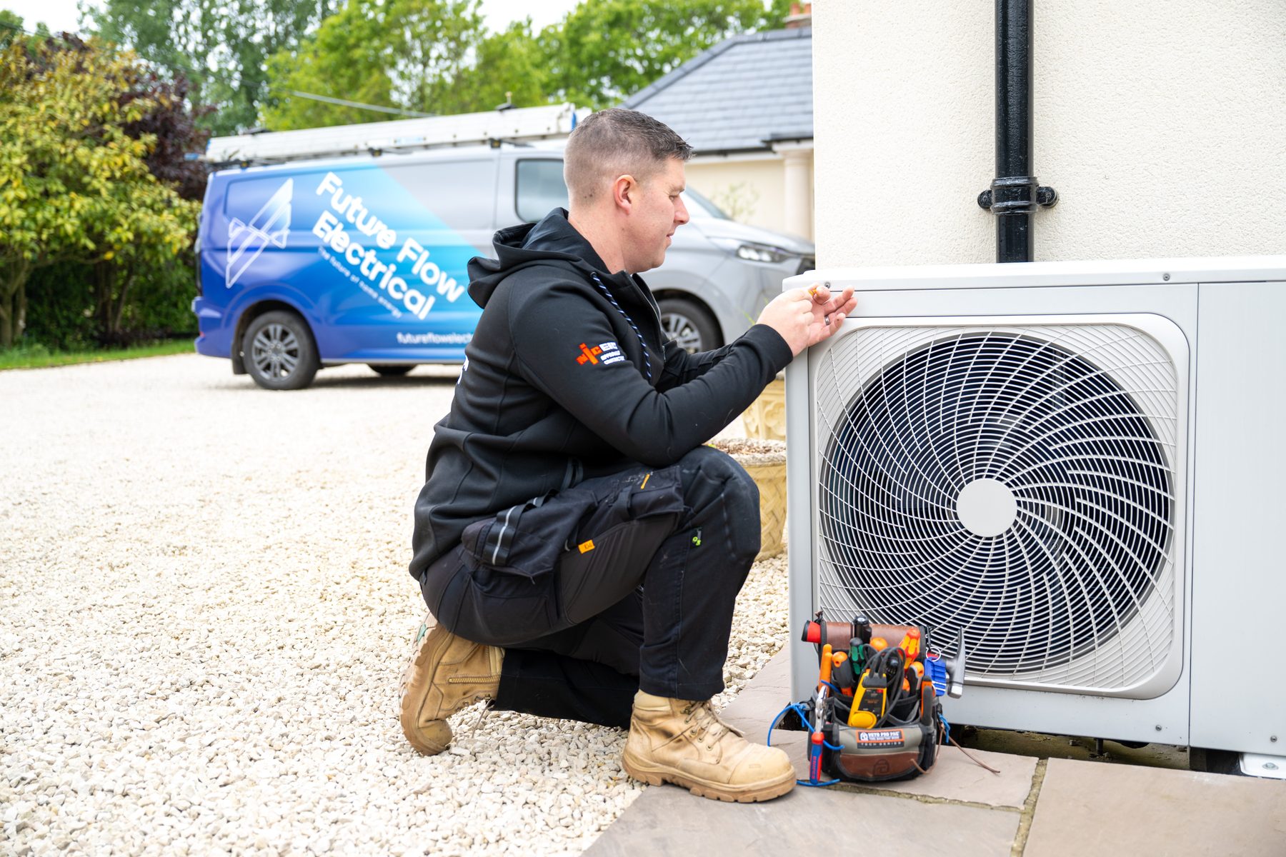 An engineer installing a heat pump at a customer's property