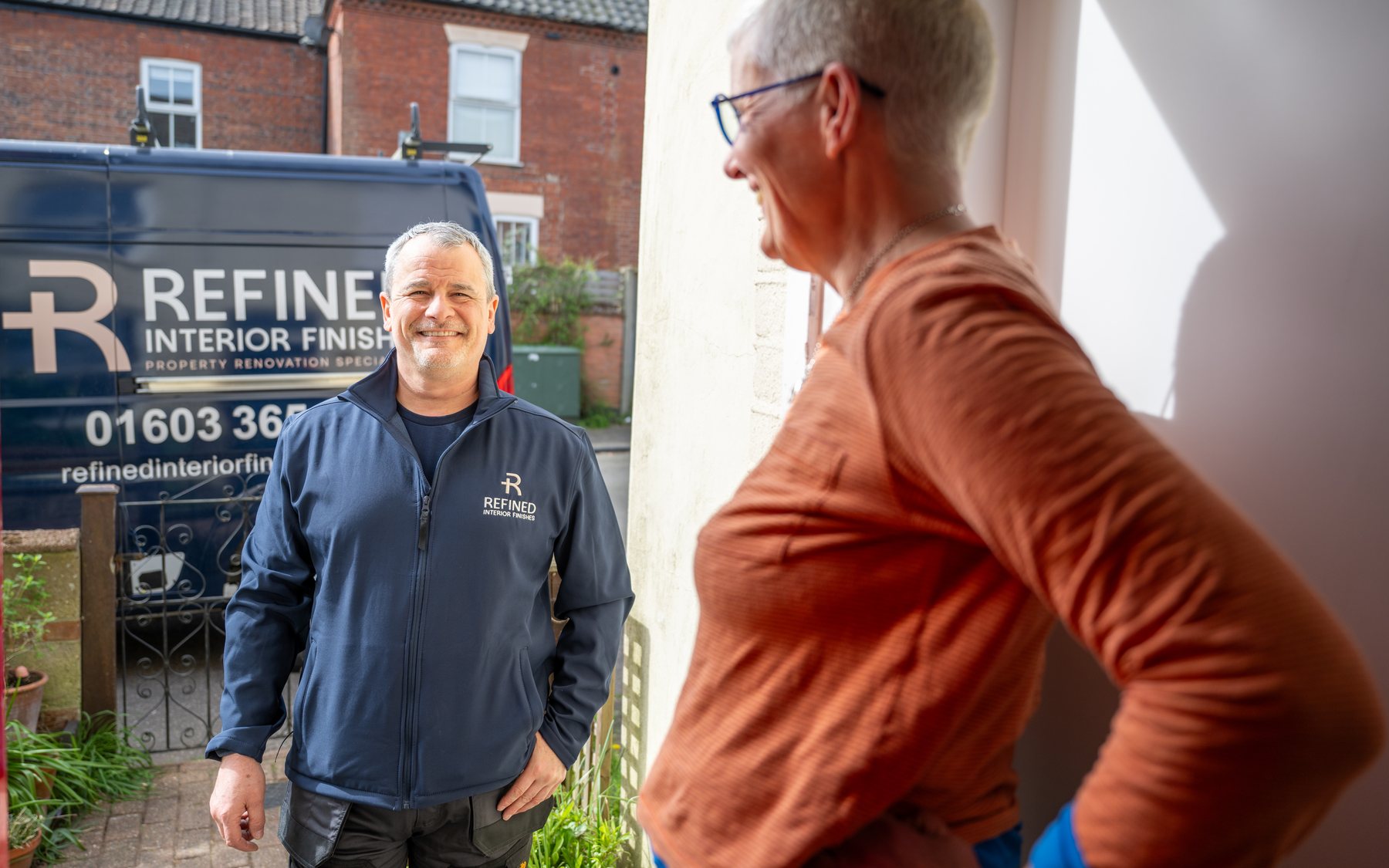 A specialist talking with a customer at her front door