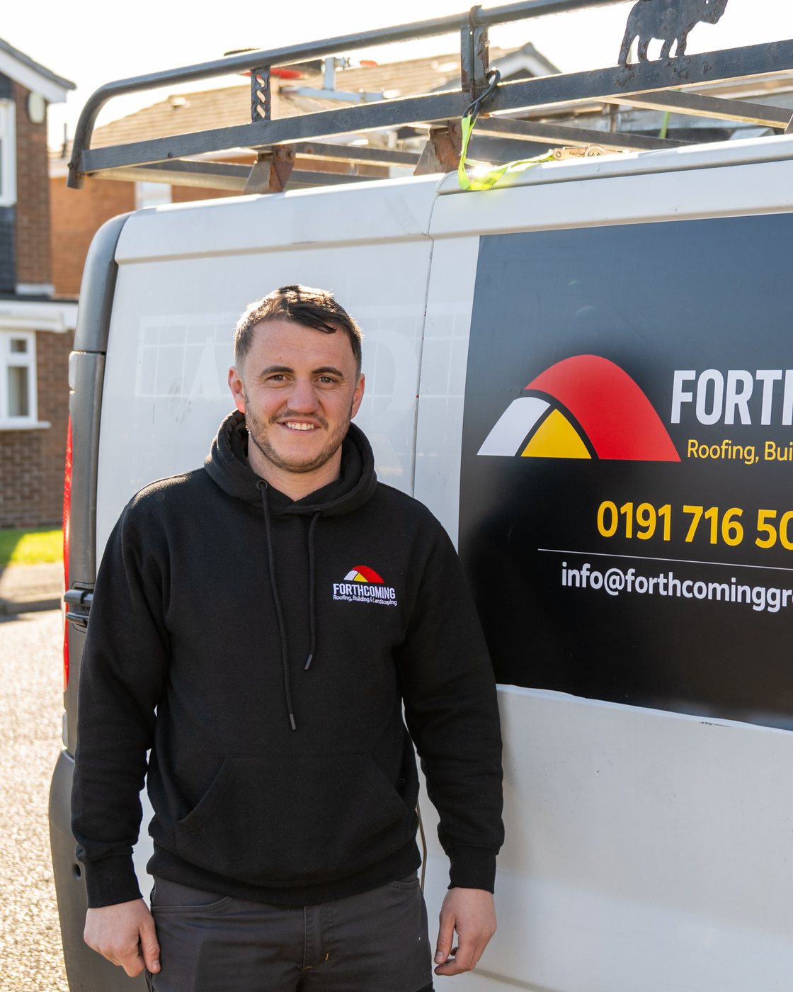 A roofer photographed beside his branded van