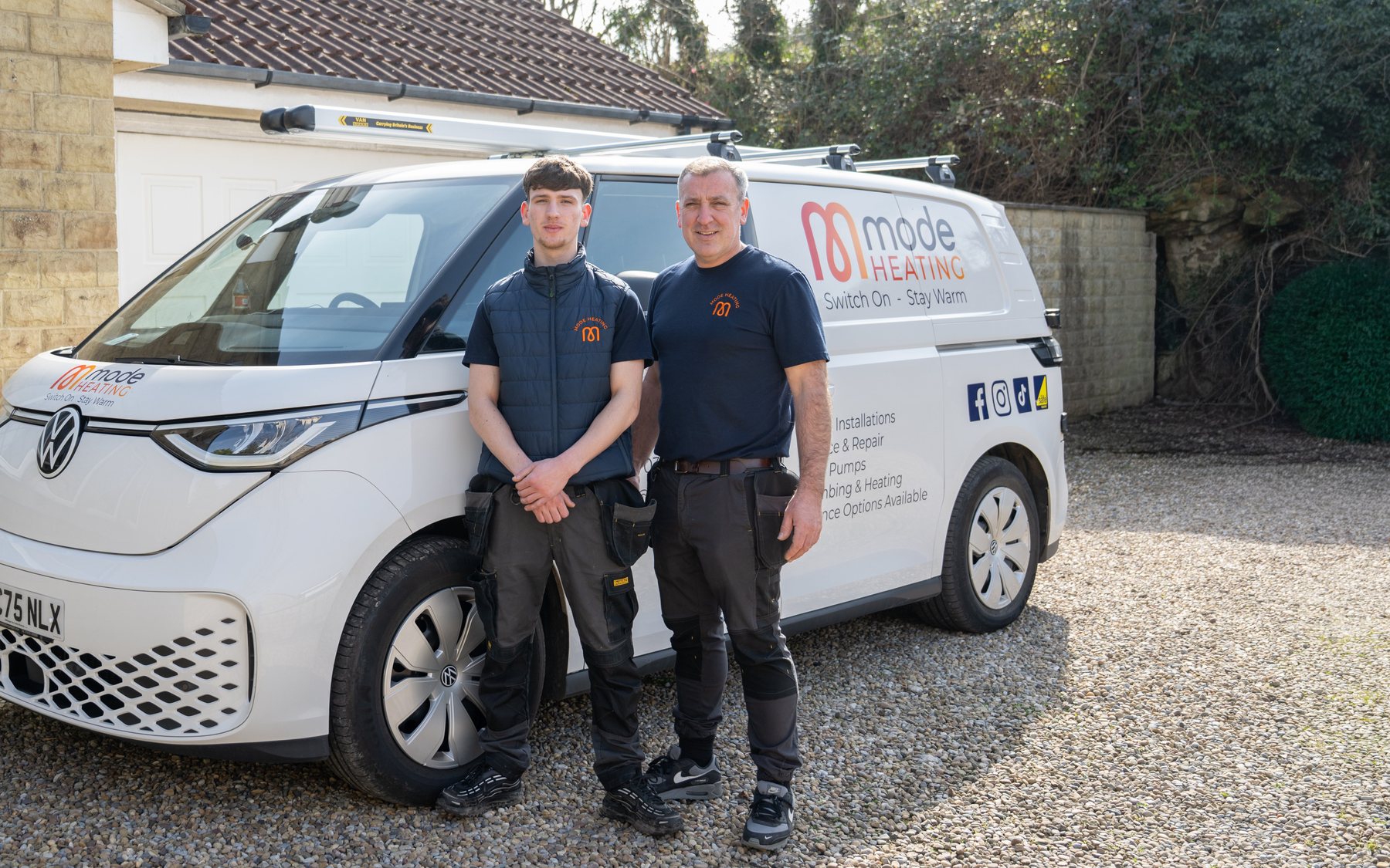 A trades team photographed with their branded van