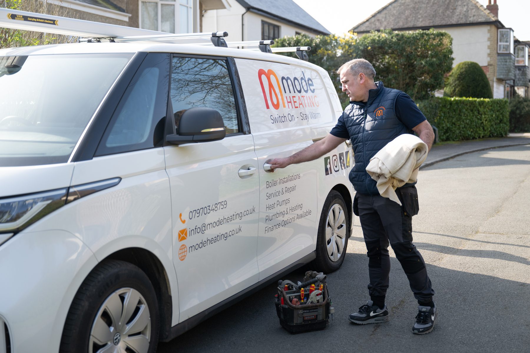 An engineer collecting tools from his branded van