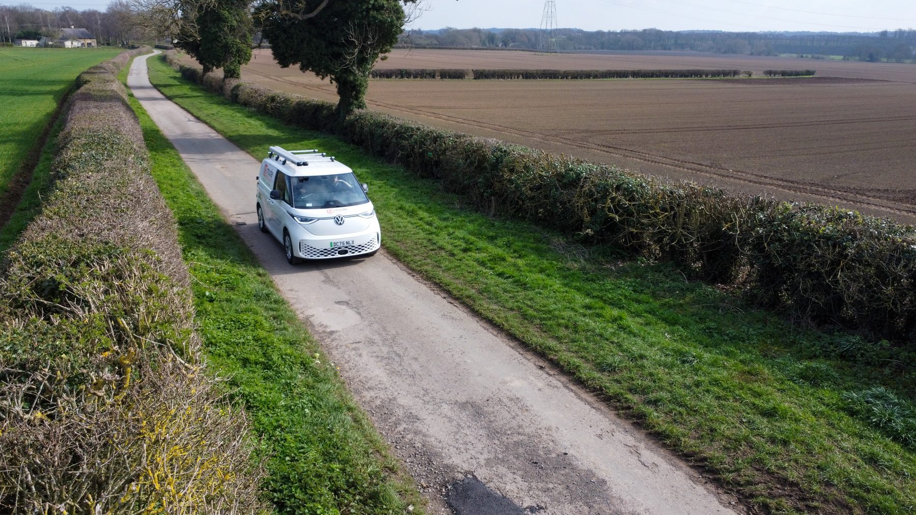 A branded van on a country lane, photographed from above